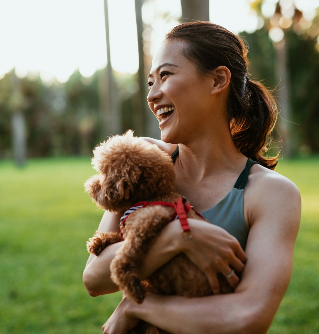 Patelco member Judy F. holds her small dog.