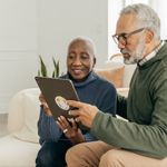 A couple manages their 401(k) plan at home on their tablet.