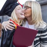 A mother hugs her college-bound daughter on graduation day.
