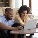 A young couple reviews their budget on their laptop.