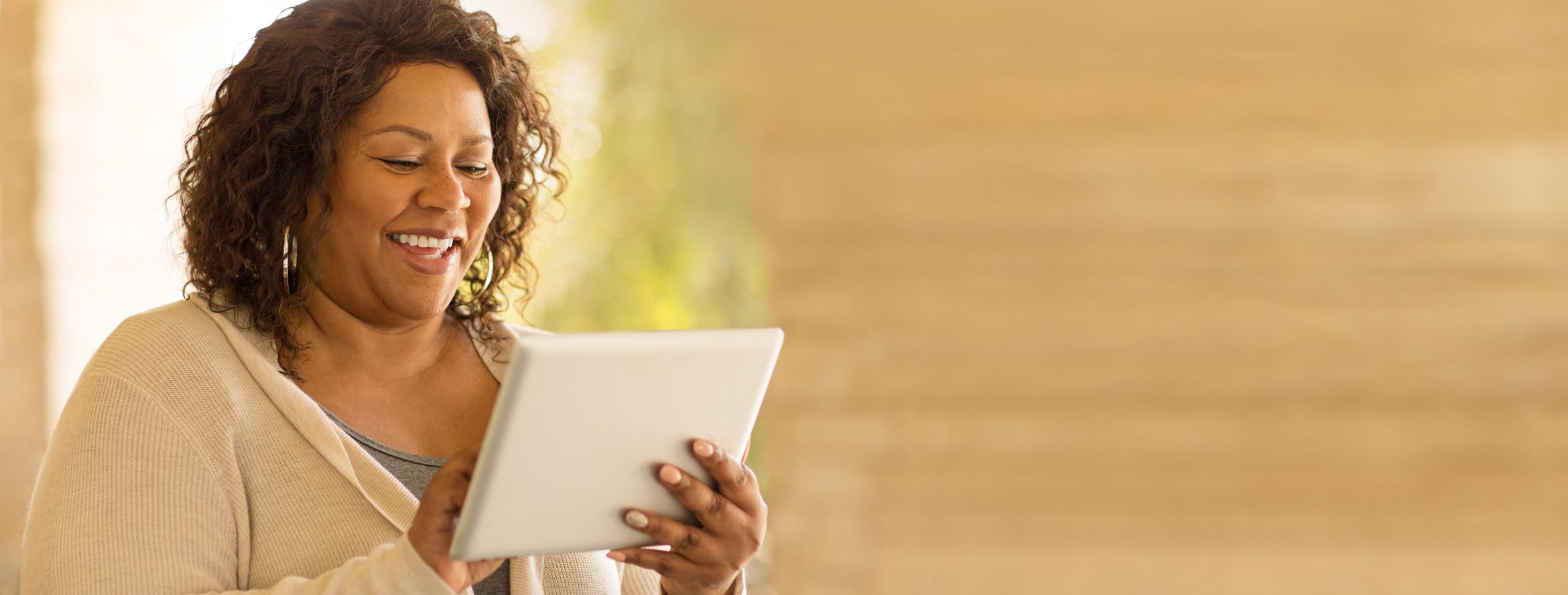 A woman pays her bills from her tablet with Patelco Online.