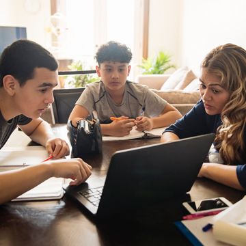 Family of three sitting at kitchen table discussing ways to stay cyber safe