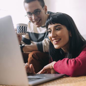 Couple looking at laptop smiling