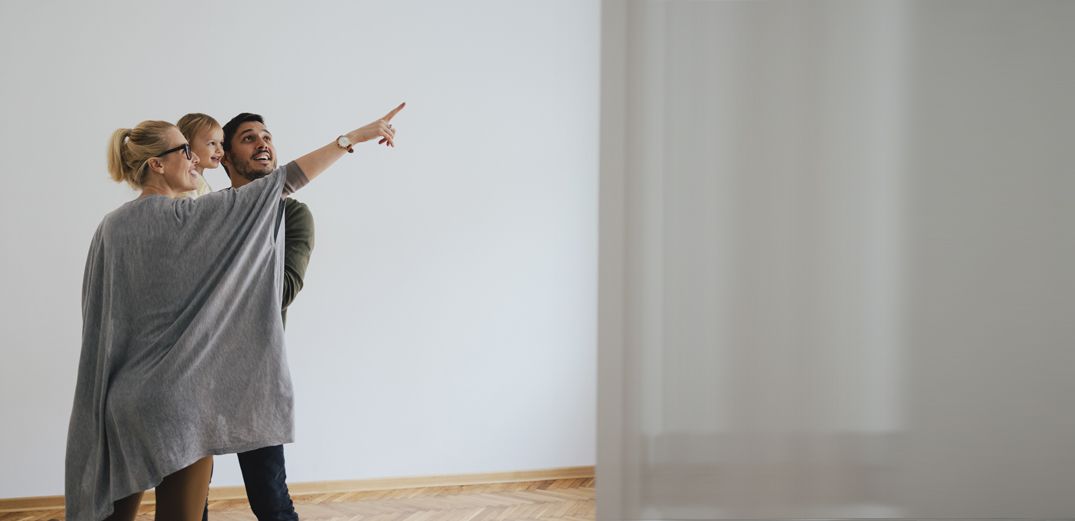 Parents hold their baby as they envision renovating their new home.