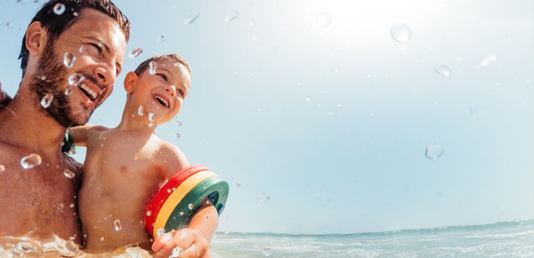 A young father and his son have fun swimming.