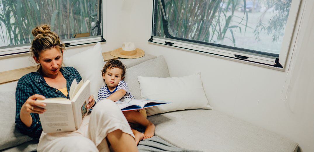 A mom and her son reading in their RV.