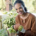 Patelco member Krystal repots a plant in her garden.