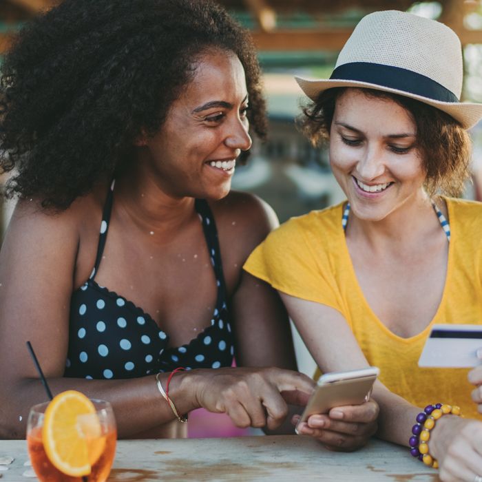 A friend transfers money from Patelco Online to her friend's account as they settle their bill at brunch.