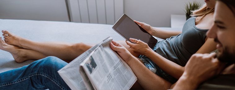 A couple reads on the couch.