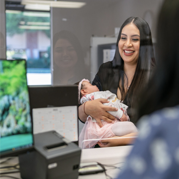 woman at credit union branch holding baby