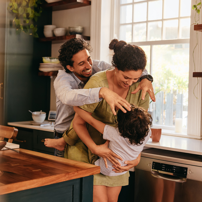 A family enjoying each other's warm embrace in their kitchen