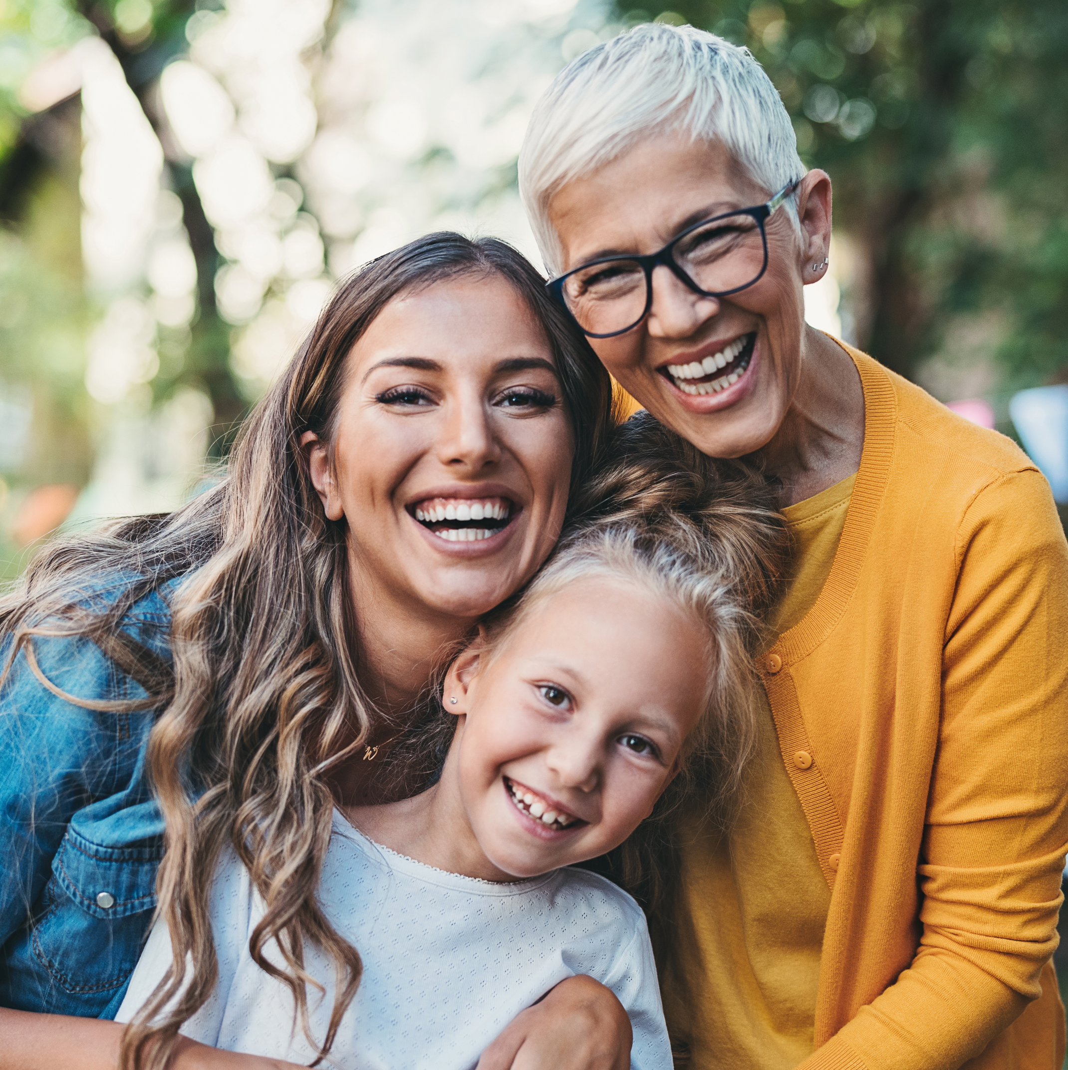 Three generations of a happy family smiling outside