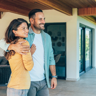 person or couple standing in front of a house