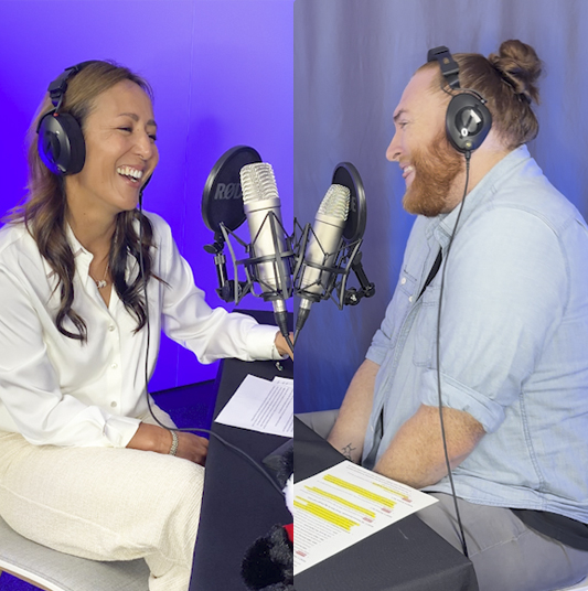 Patelco employees Michele Enriquez and Andrew Farrell speaking into microphones at the podcast desk.
